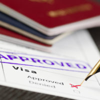 Visa application approved, close up shot of a form, passports and pen.