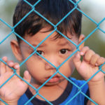 Little boy behind a fence left behind Little boy behind a fence left behind
