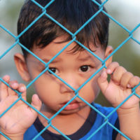 Little boy behind a fence left behind Little boy behind a fence left behind