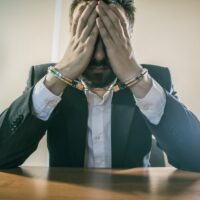 male businessman in handcuffs as a symbol of corruption