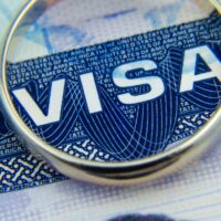 Macro photo of US entry visa sticker in a passport and a ring. Conceptual photo for fiancee visa and immigration. Selective focus.