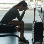 A passenger waiting at the airport terminal stressed out at tired.