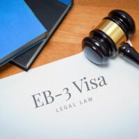 EB-3 Visa. Document with label. Desk with books and judges gavel