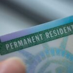 Close up view of Fragment of Permanent resident card (Green) card of USA on blurred background.